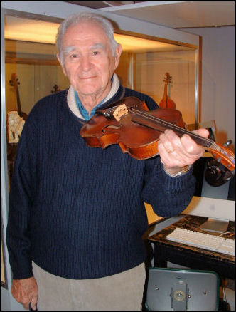 Don Watson holding a violin made by Nehemiah Watson